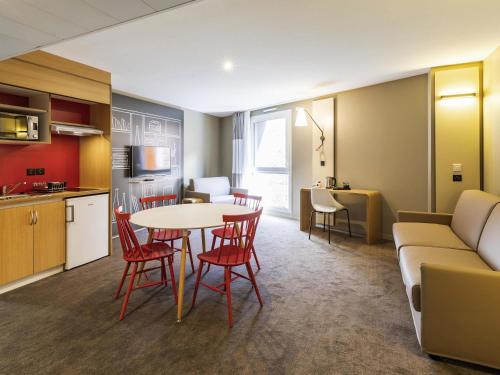 a kitchen and a living room with a table and chairs at ibis Saint Malo Plage in Saint Malo