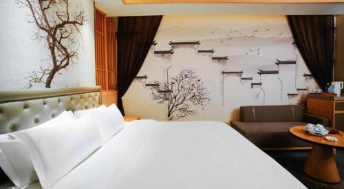 a bedroom with a large white bed and a couch at Quanzhou Binhai Hotel in Quanzhou