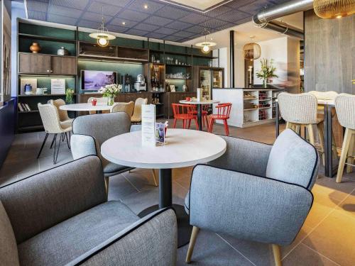 a restaurant with tables and chairs and a kitchen at ibis Saint Malo Plage in Saint Malo