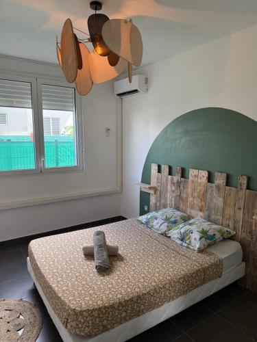 a bedroom with a bed with a teddy bear on it at Cocon Montabo - logement tout équipé avec climatisation et Wi-Fi - à seulement 5 min de la plage in Cayenne