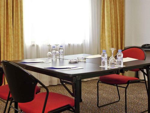 a black table with red chairs and water bottles on it at Novotel Andorra in Andorra la Vella
