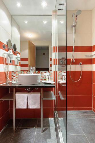 a bathroom with a sink and a shower at Mercure München City Schwabing in Munich