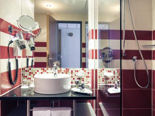 a bathroom with a sink and a shower at Mercure München City Schwabing in Munich