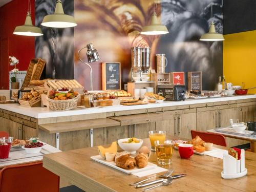 a restaurant with a table with bread and pastries at ibis Gap Centre in Gap
