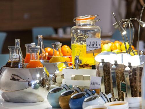 a table with a bunch of fruit and a jar of juice at Mercure Paris Vaugirard Porte De Versailles in Paris
