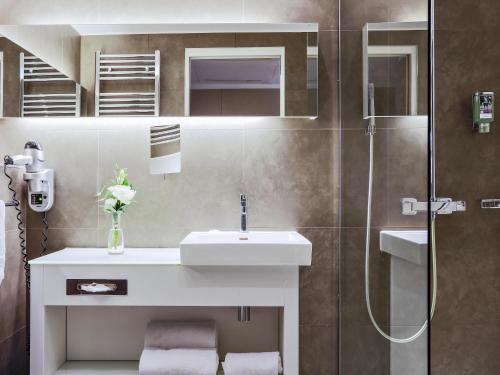 a bathroom with a sink and a shower at Mercure Paris Vaugirard Porte De Versailles in Paris