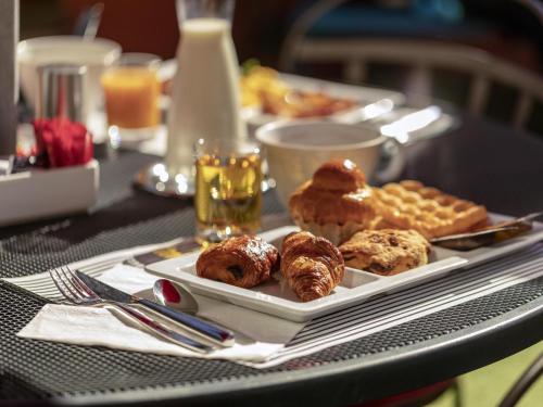 een tafel met een bord eten op een tafel bij Novotel Nice Centre Vieux Nice in Nice