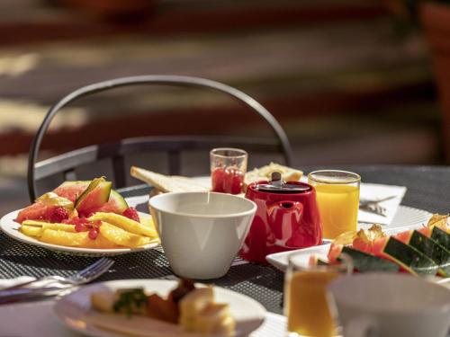 een tafel met borden met eten en drinken bij Novotel Nice Centre Vieux Nice in Nice