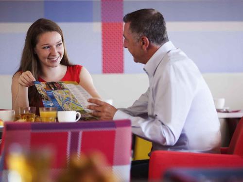 a man and a woman sitting at a table at Mercure Strasbourg Centre in Strasbourg