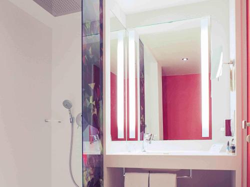 a bathroom with a sink and a mirror at Mercure Lille Marcq en Baroeul in Marcq-en-Baroeul
