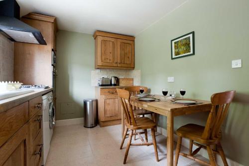 a kitchen with a wooden table and chairs in it at Chinley End Farm in Chinley