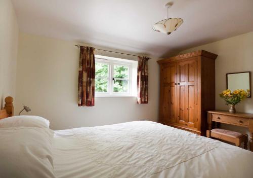 a bedroom with a white bed and a window at Chinley End Farm in Chinley