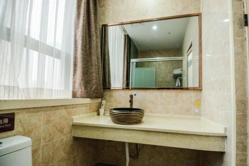 a bathroom with a sink and a mirror at 7Days Premium Yichang Railway Station East in Yichang