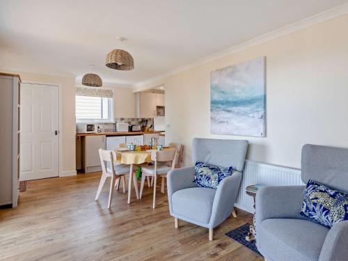 a living room with a table and chairs and a kitchen at 2 Bed in West Quantoxhead 96234 in West Quantoxhead