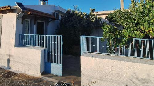 a white house with a gate and a fence at Eve's house in Mokhós