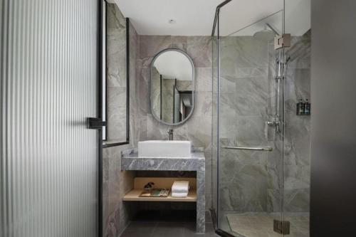 a bathroom with a sink and a shower at Immersing Hotel Guilin Two Rivers and Four Lakes Dongxi Alley in Guilin