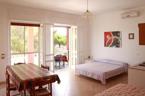 1 dormitorio con 2 camas, mesa y balcón en Villa Giovanna, en Nardò
