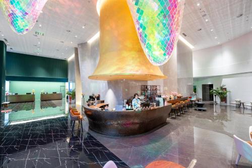 a restaurant with a large bell hanging from the ceiling at 青岛若七酒店 Luxseven Hotel in Qingdao