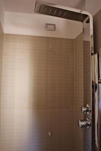 a shower in a bathroom with brown tiles at Primavera Mini Hotel in Perugia