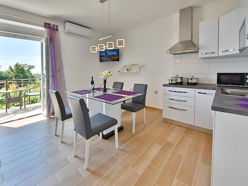 eine Küche mit einem Tisch und Stühlen sowie eine Küche mit einem Balkon in der Unterkunft Apartments Garden Residence in Opatija