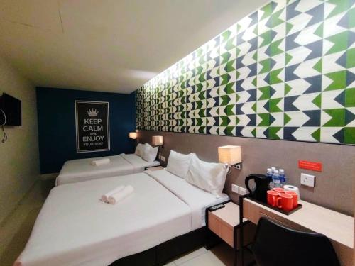 a hotel room with two beds and a checkered wall at Sovotel@Uptown 28 in Petaling Jaya