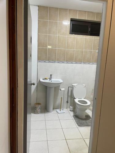 a bathroom with a toilet and a sink at Heiteahi lodge house large courtyard in Punaauia