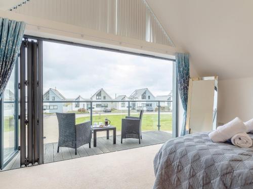 a bedroom with a bed and a large sliding glass door at 3 Bed in Westward Ho 52930 in Northam