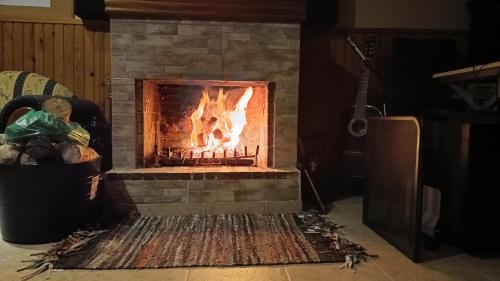 a brick fireplace with a fire in it at Koufos House in Sparti
