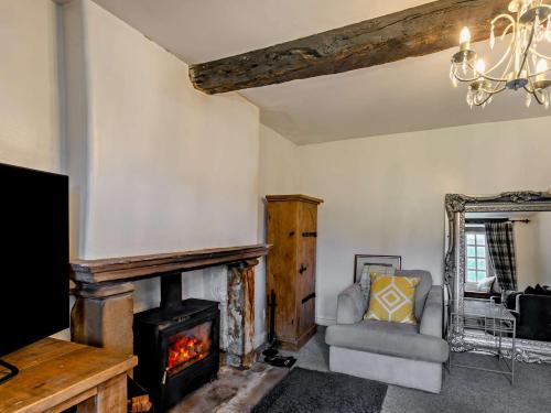 a living room with a fireplace and a chair at 4 Bed in Clitheroe 94409 in Newton