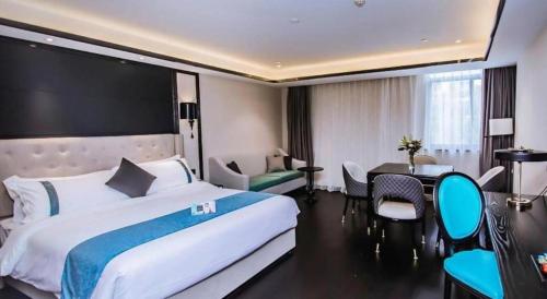 a hotel room with a large bed and a desk at Xana Hotelle Wuxi Railway Station Zhongshan Road in Wuxi