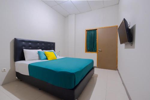 a bedroom with a bed and a flat screen tv at Athena Syariah Residence in Tangerang