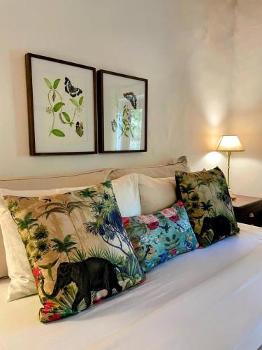 a bed with two pillows and a black dog on it at Bawlana Estate - Kandy in Kandy