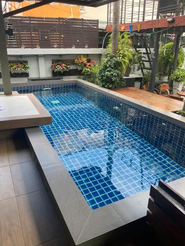 a swimming pool with blue tiles in a building at Suvarnabhumi Mansion in Samutprakarn