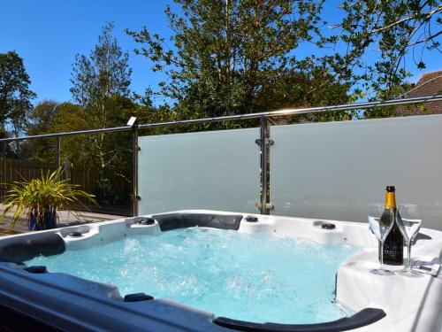 a jacuzzi tub with a bottle of champagne in it at 4 Bed in Bude 89355 in Poughill