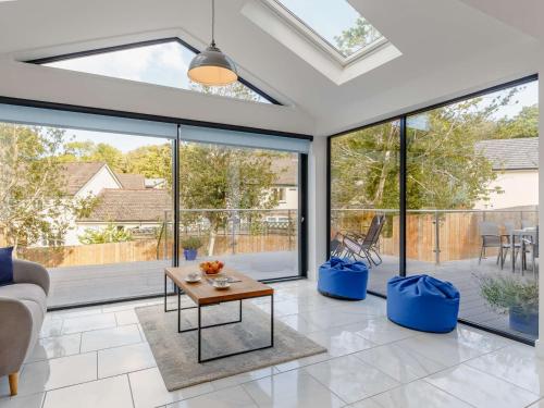 a living room with large windows and a couch at 4 Bed in Bude 89355 in Poughill