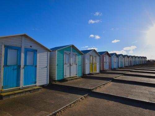 a row of colourful beach huts on the beach at 4 Bed in Bude 89355 in Poughill