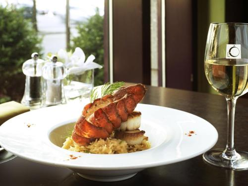 a plate of food on a table with a glass of wine at Novotel Montreal Center in Montréal