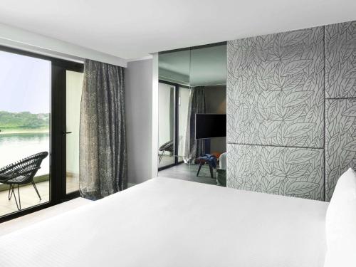 a bedroom with a large bed and a large window at Pullman Abidjan in Abidjan