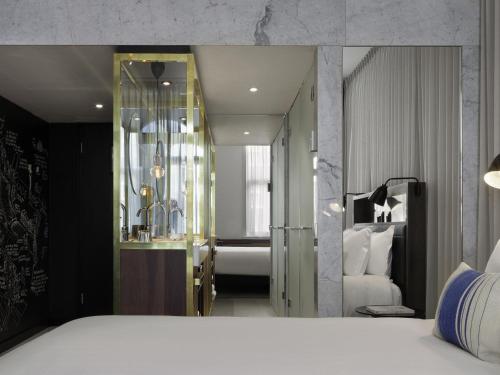 a hotel room with a bed and a mirror at INK Hotel Amsterdam - MGallery Collection in Amsterdam