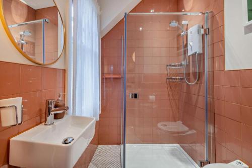 Un baño con ducha de cristal y lavabo. en Kingston House, en Cromer
