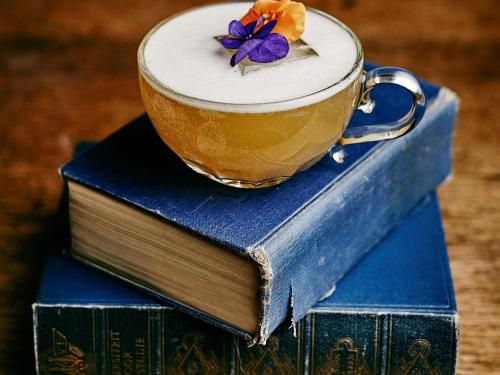 a cup of coffee sitting on top of two books at INK Hotel Amsterdam - MGallery Collection in Amsterdam