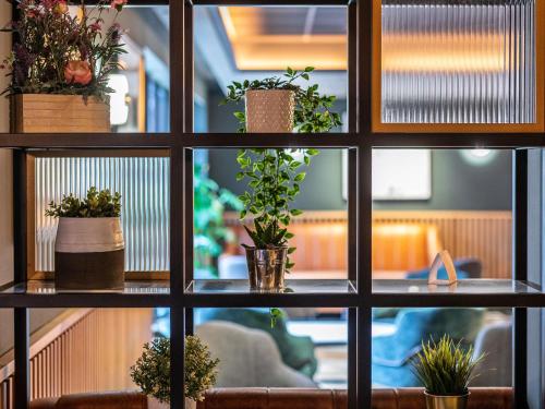 a view through a window with potted plants at Novotel Birmingham Airport Terminal Building - NEC in Bickenhill