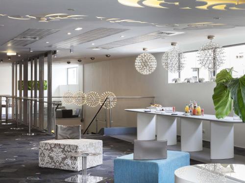 a lobby with a table and chairs and lights at Mercure Marseille Centre Vieux Port in Marseille