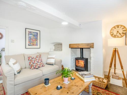 a living room with a white couch and a wood stove at 1 Bed in Newton St Margarets 93134 in Bacton