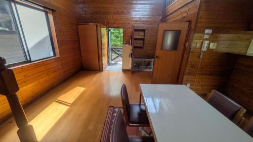 佐伯市にあるうめキャンプ村のキャビン内のテーブルと椅子付きの部屋