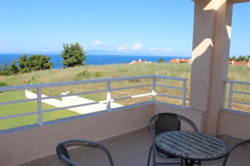a balcony with chairs and a table and the ocean at Petra in Afitos