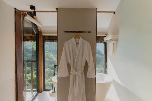 a robe hanging on a wall in a bathroom at Gia Trang Heian Hoa Binh in Hòa Bình