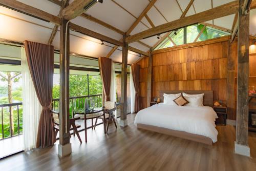 a bedroom with a bed in a room with windows at Gia Trang Heian Hoa Binh in Hòa Bình