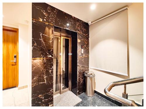 a bathroom with a black marble wall at Q Saina RG Varanasi in Varanasi