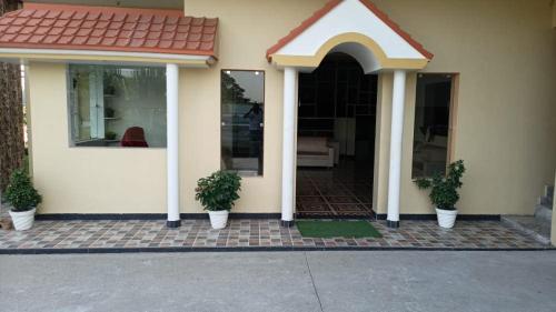a house with two potted plants in front of it at Hotel O Ocean's 11 in Daurāla